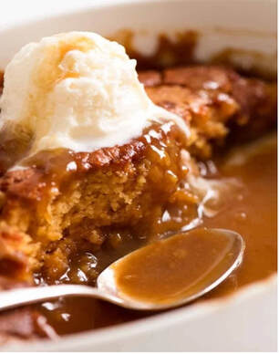 A warm slice of pecan pie topped with vanilla ice cream and caramel sauce.