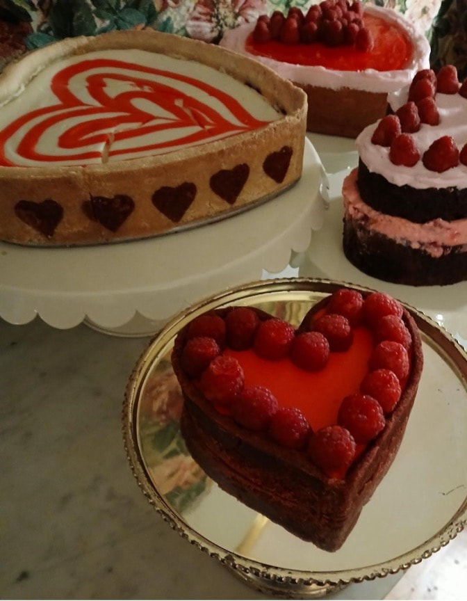 Heart-themed desserts with vibrant red accents on display.
