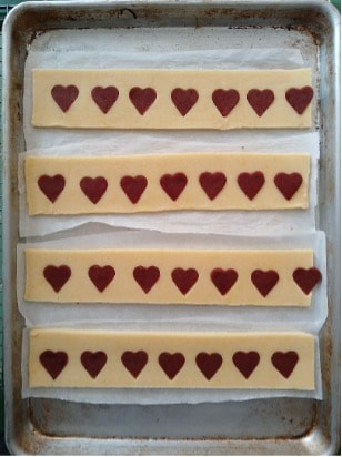 Rows of rectangular cookies with chocolate hearts on top.