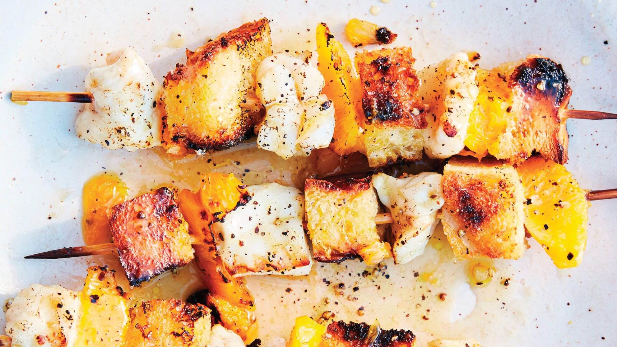 Grilled bread cubes with herbs and seasoning on parchment paper.