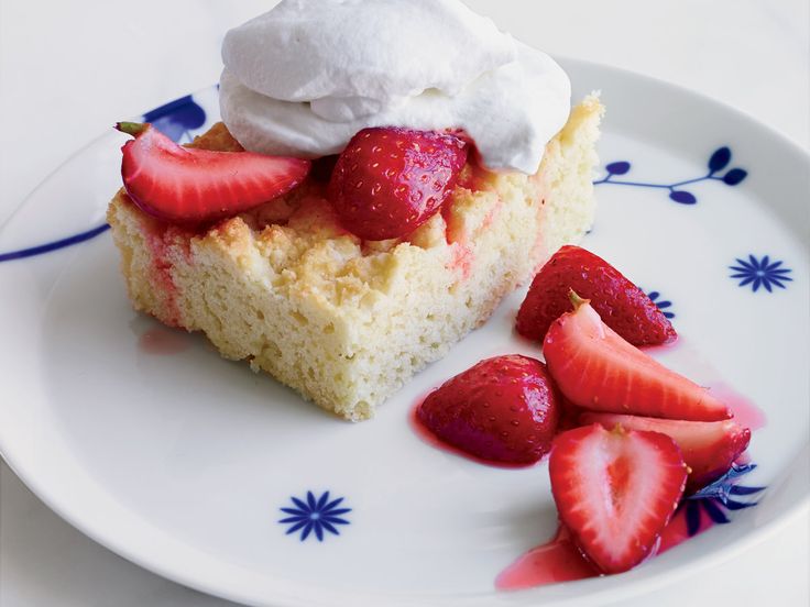 A slice of cake topped with whipped cream and fresh strawberries.