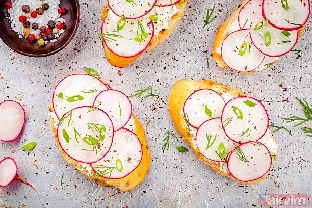 Open-faced sandwiches with radish slices and herbs on bread.