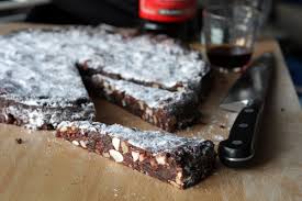 A rich chocolate and nut tart with a slice cut out.