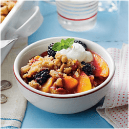 A bowl of fruit and lentil salad topped with yogurt and herbs.