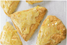 Golden triangular scones with a glossy glaze on top.