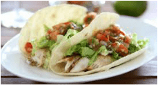 Two soft tacos filled with grilled chicken, lettuce, and salsa.