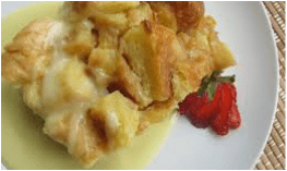 Close-up of fried food with creamy sauce and strawberry garnish.