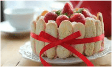 A strawberry cake decorated with ladyfingers and a red ribbon.