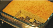 Close-up of a baked crumbly dessert in a glass dish.