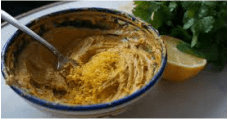 Bowl of seasoned butter with lemon zest and herbs.