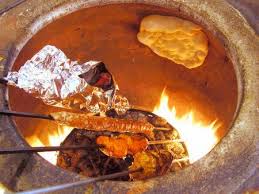 Traditional tandoor oven cooking kebabs and naan bread.