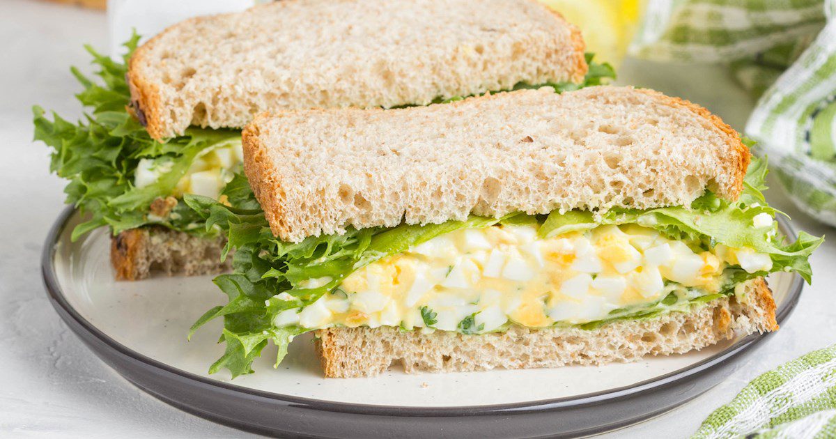Egg salad sandwich with lettuce on whole wheat bread.