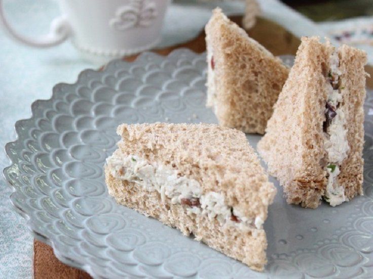 Triangular sandwiches with a creamy filling on a decorative plate.