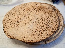 A stack of round, speckled flatbreads on a plate.