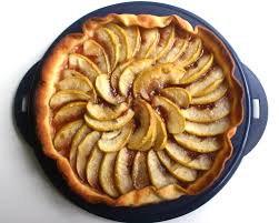 A golden-brown apple tart with fanned apple slices.