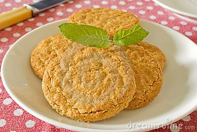 A plate of golden brown cookies garnished with mint leaves.