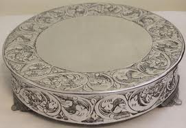 Ornate round metal box with intricate floral engravings.