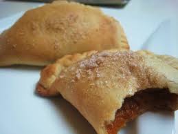 Two baked empanadas, one partially eaten.