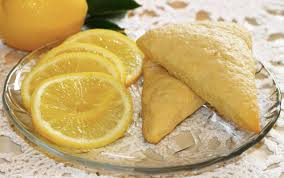 Lemon-filled pastries with sliced lemons on a plate.