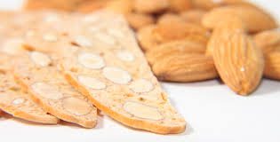Close-up of almond biscotti with almonds in the background.