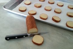 Sliced loaf of bread with slices on a baking tray.