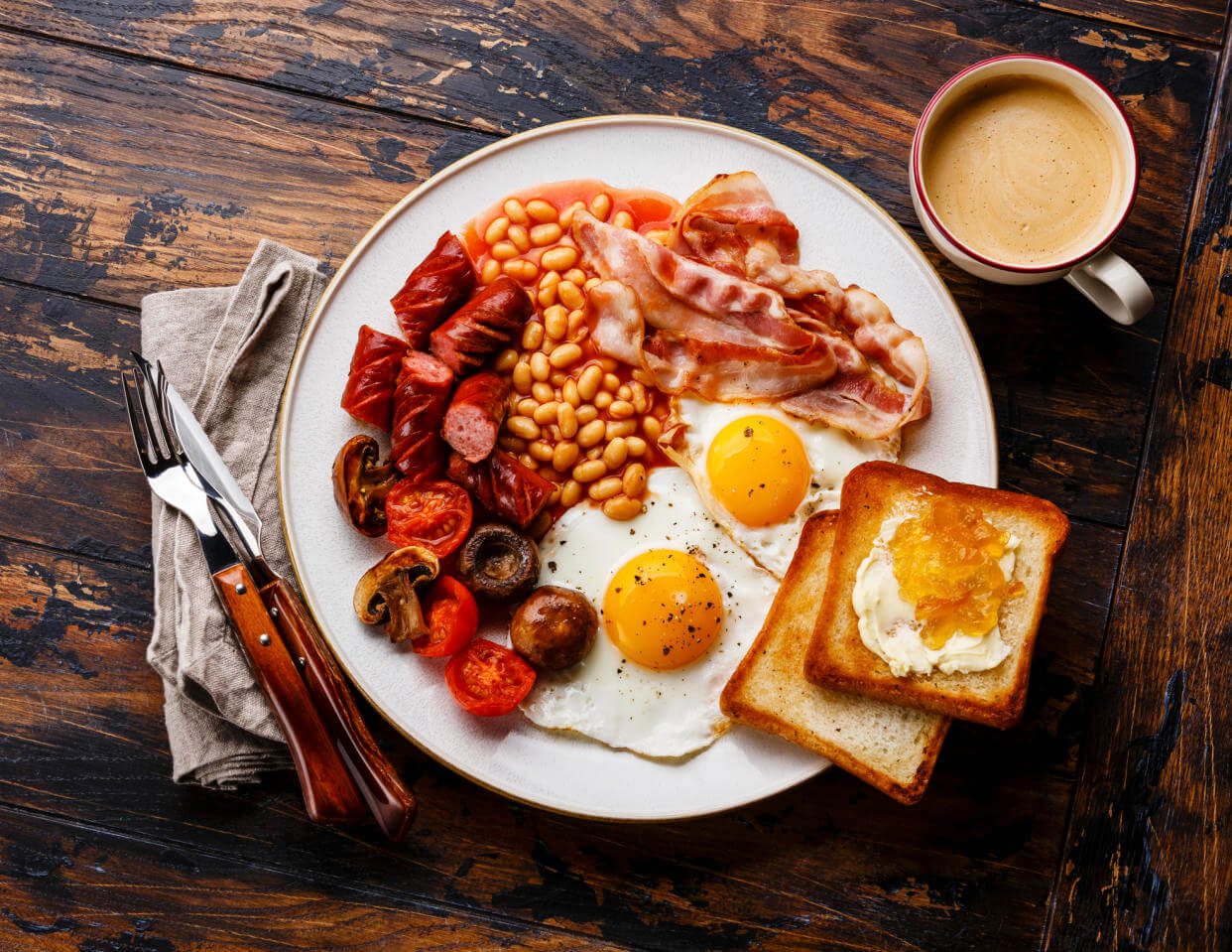 A classic full English breakfast with eggs, bacon, beans, toast, and sausage.