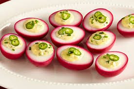 Boiled eggs with a creamy filling and green chili slices.