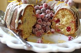 A sliced cranberry cake with icing on a decorative plate.