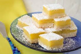 Lemon bars dusted with powdered sugar on a plate.