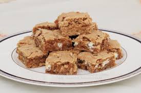 A plate of homemade blondies with white chocolate chips.