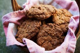 Basket of freshly baked oatmeal cookies on a pink cloth.