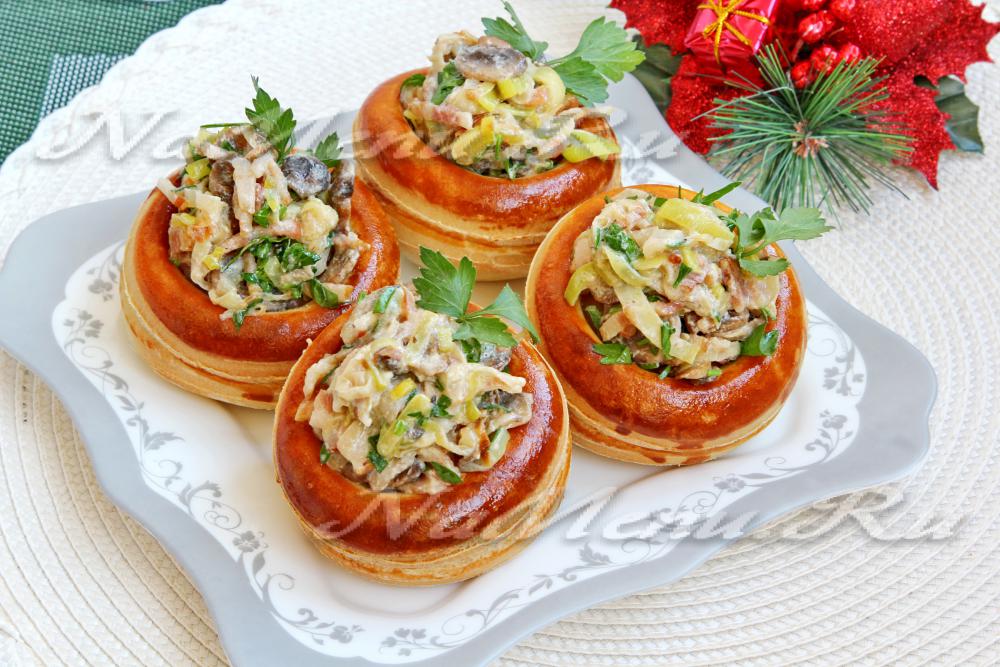Stuffed mushrooms topped with creamy chicken and herbs, served on a decorative plate.