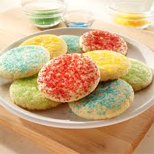 Colorful sugar-coated cookies arranged on a white plate.