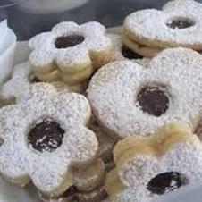 Powdered sugar flower-shaped cookies with chocolate centers.