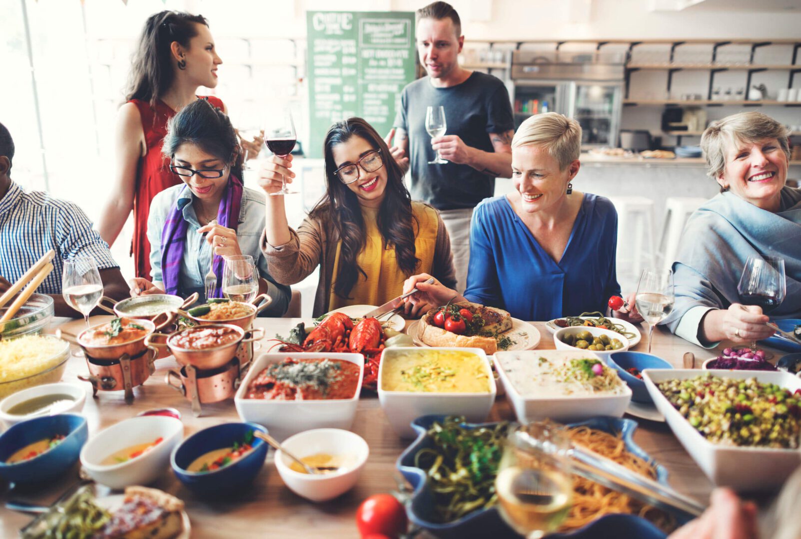 Friends joyfully sharing a diverse meal together at a cozy gathering.