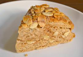A slice of nut-topped cake on a white plate.