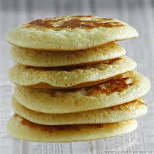 Stack of fluffy pancakes with golden-brown tops.