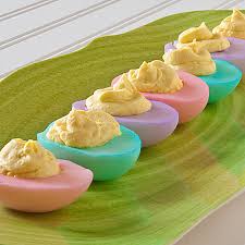 Colorful deviled eggs arranged on a green leaf-shaped plate.