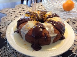 Chocolate and vanilla bundt cake with syrup drizzle on a white plate.