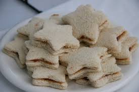 Star-shaped cream-filled sandwich cookies on a plate.