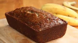 A freshly baked loaf of banana bread on a wooden surface.