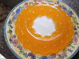 A plate of orange jelly dessert with a creamy center.