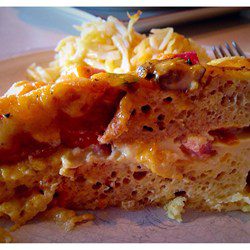 Close-up of a loaded breakfast sandwich with eggs and meat.