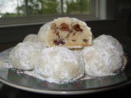 Snowball cookies dusted with powdered sugar on a plate.