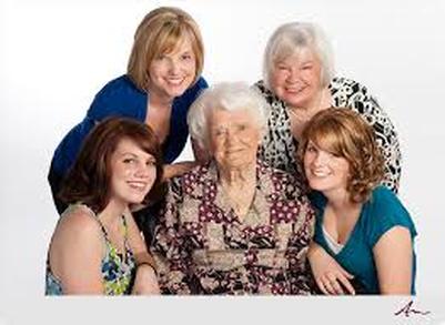 Five women of different generations smiling together in a family photo.