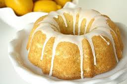 Bundt cake with icing drizzle on a white plate.