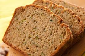 Two slices of herb-speckled bread on a wooden surface.