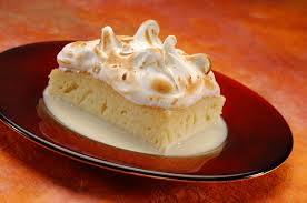 A slice of lemon meringue pie with toasted peaks on a red plate.