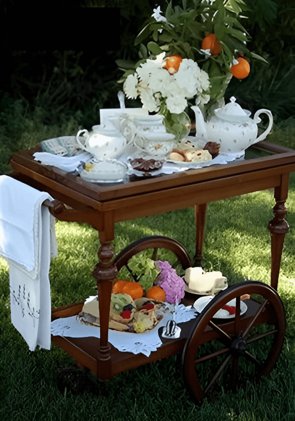 Elegant outdoor tea setup with fine china and fresh flowers.