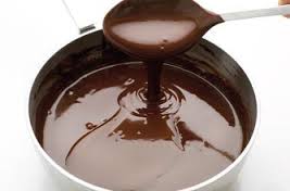 Rich melted chocolate being poured from a spoon.
